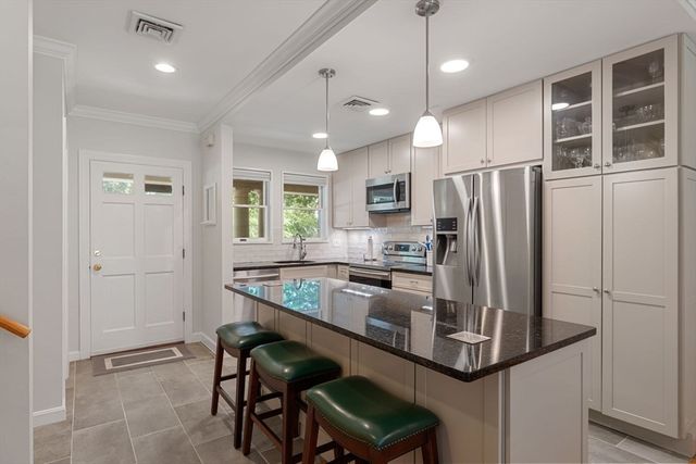 a kitchen with kitchen island a refrigerator dining table and chairs