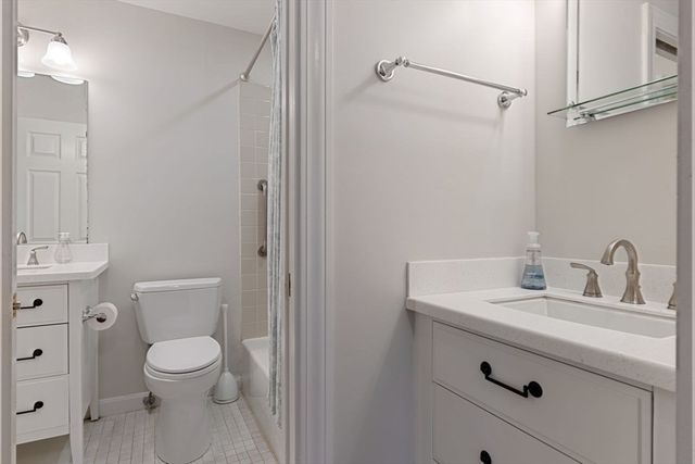 a bathroom with a toilet sink vanity and mirror