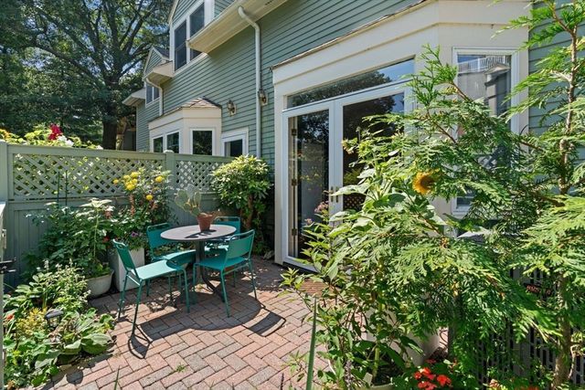 a view of a chair and table in the garden front of house