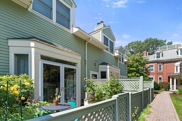 a view of a brick house with a flower garden