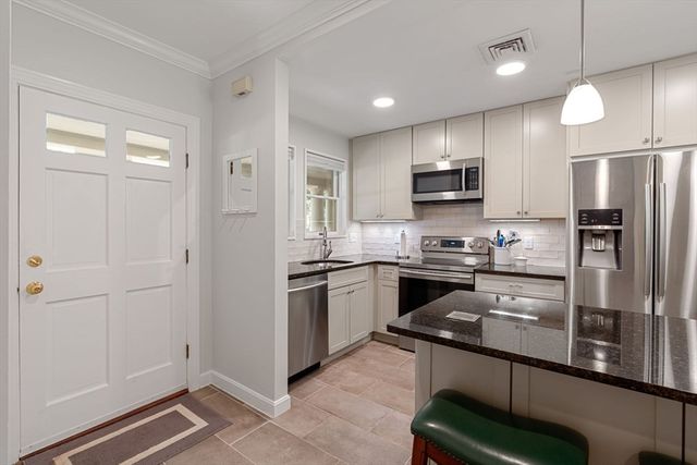 a kitchen with stainless steel appliances granite countertop a stove refrigerator and microwave