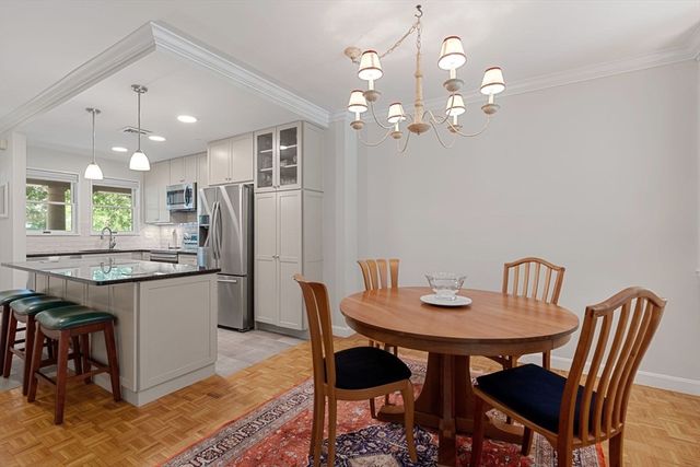 a kitchen with a dining table chairs and refrigerator