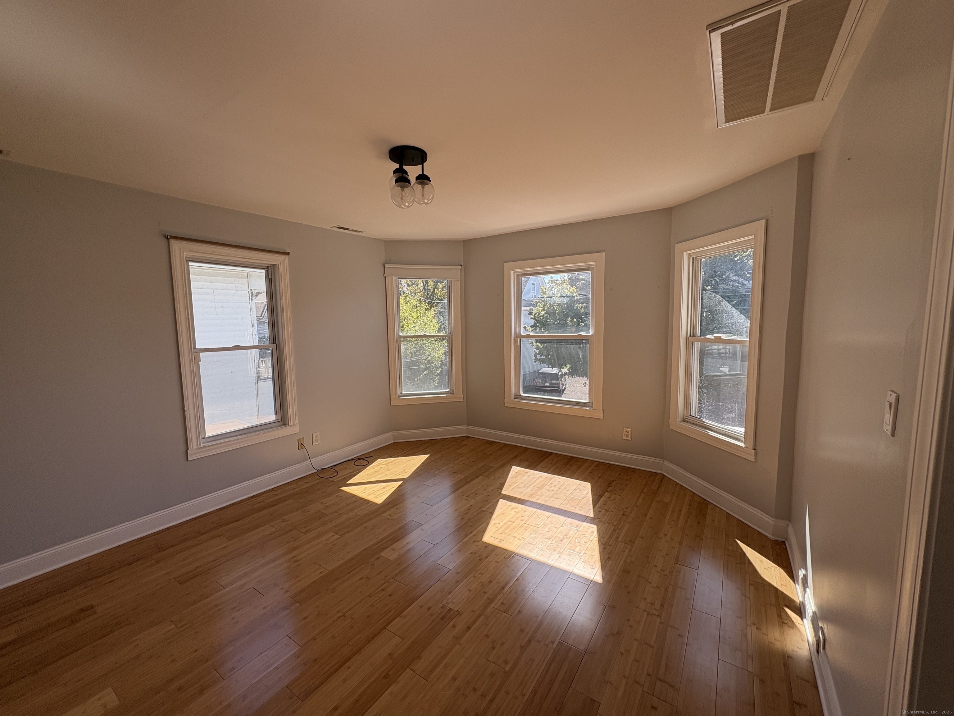 679 Shelton Street, Unit 2 Bridgeport, CT 06608 - Photo 4 of 25 a view of an empty room with wooden floor and a window