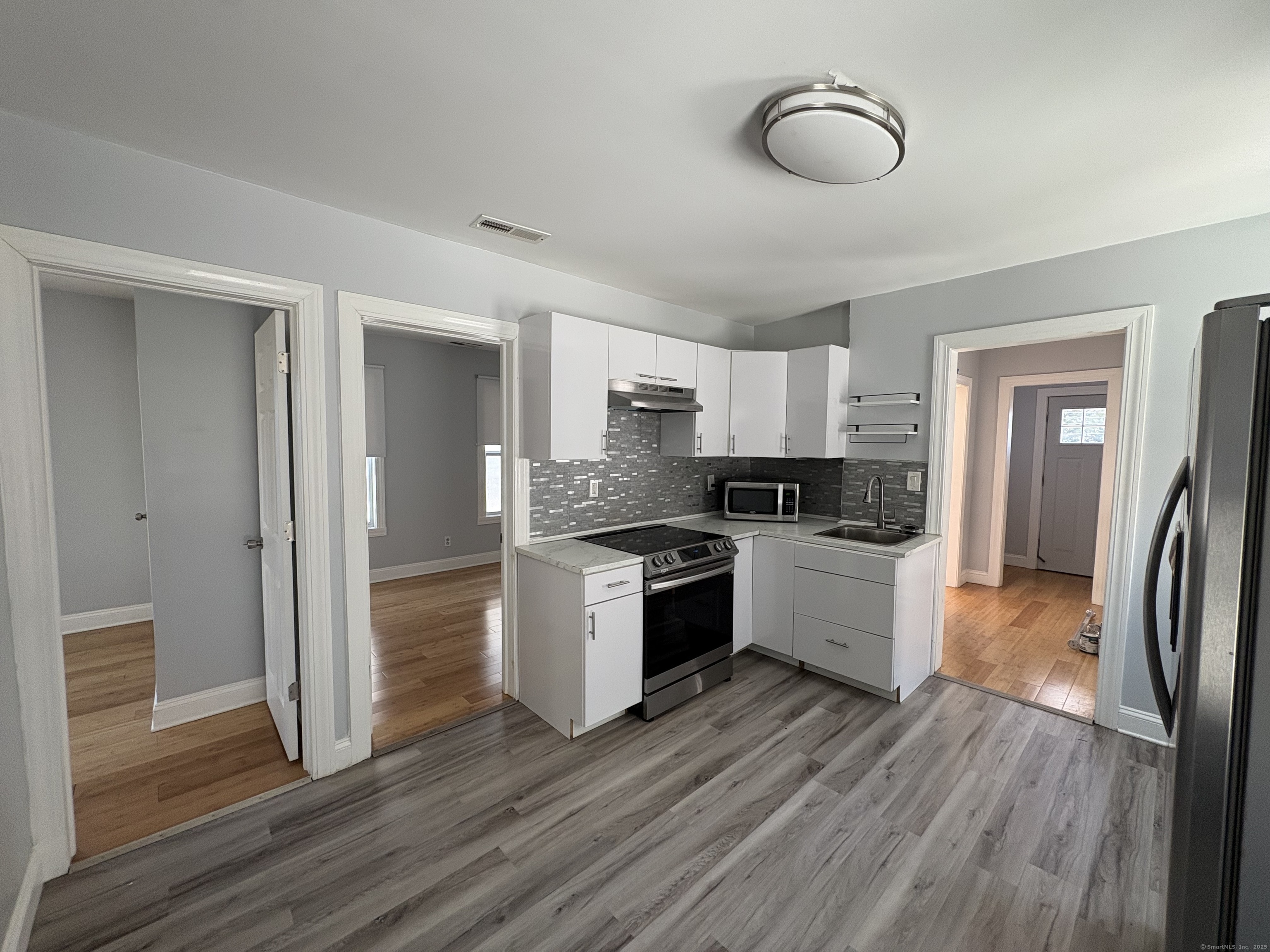 679 Shelton Street, Unit 2 Bridgeport, CT 06608 - Photo 8 of 25 a kitchen with granite countertop a refrigerator cabinets and wooden floor