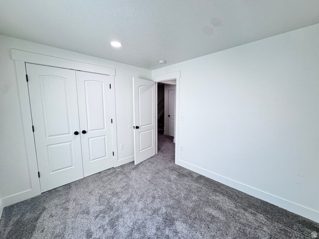 4729 Middleboro Road Herriman, UT 84096 - Photo 17 of 19 Spacious room featuring plush gray carpeting, white walls, white trim, recessed lighting, and a double-door closet with matte black hardware