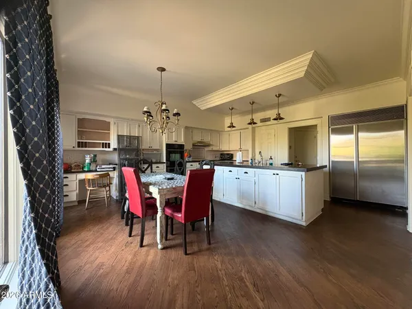 a kitchen with stainless steel appliances kitchen island granite countertop a dining table chairs and granite counter tops