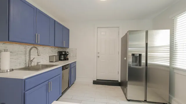 a kitchen with a refrigerator sink and cabinets