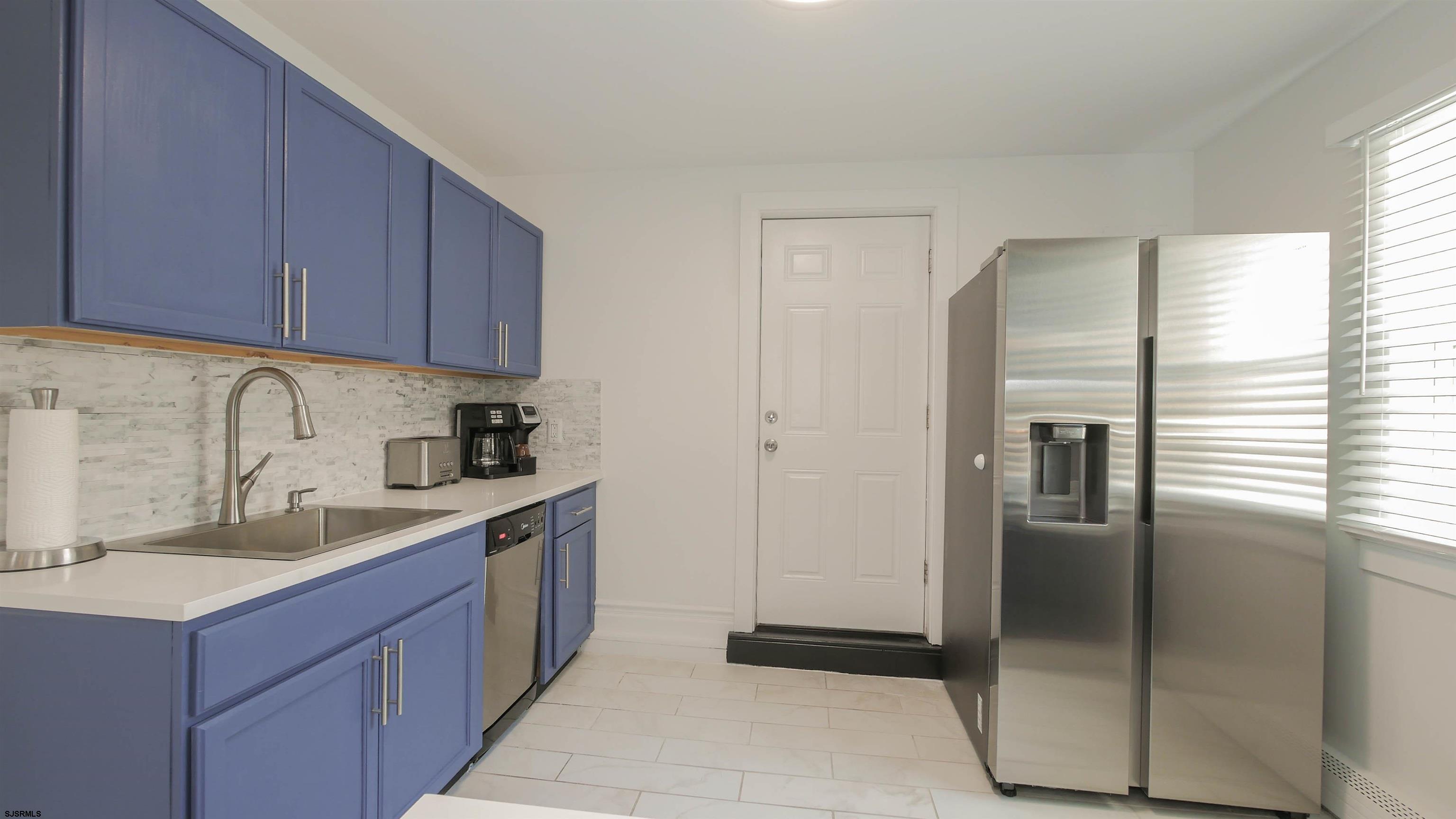 11 South Washington Avenue, Unit 2 Margate City, NJ 08402 - Photo 13 of 35 a kitchen with a refrigerator sink and cabinets