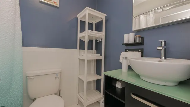 a bathroom with a toilet a sink and a mirror