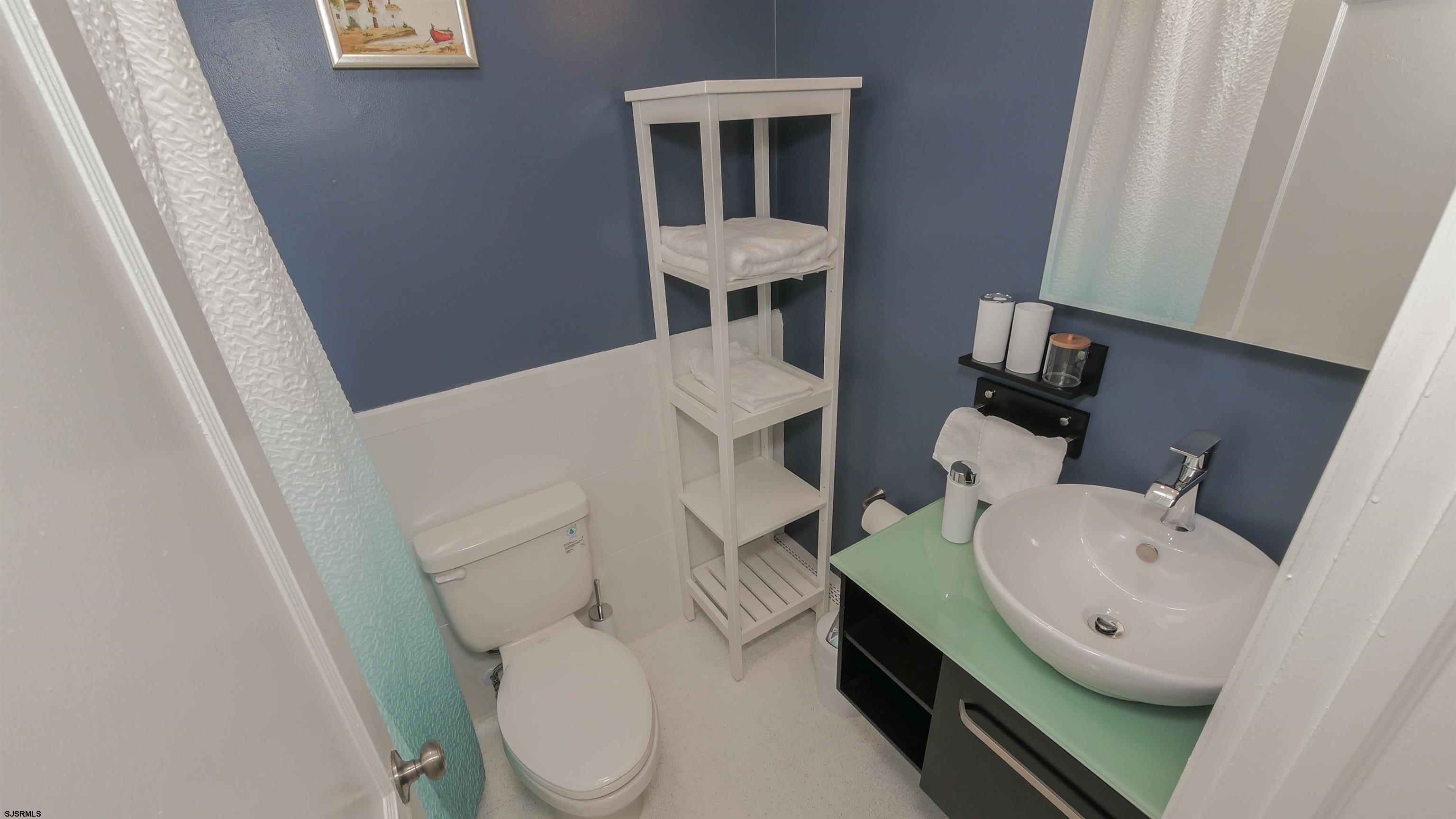 11 South Washington Avenue, Unit 2 Margate City, NJ 08402 - Photo 25 of 35 a bathroom with a toilet a sink and a mirror