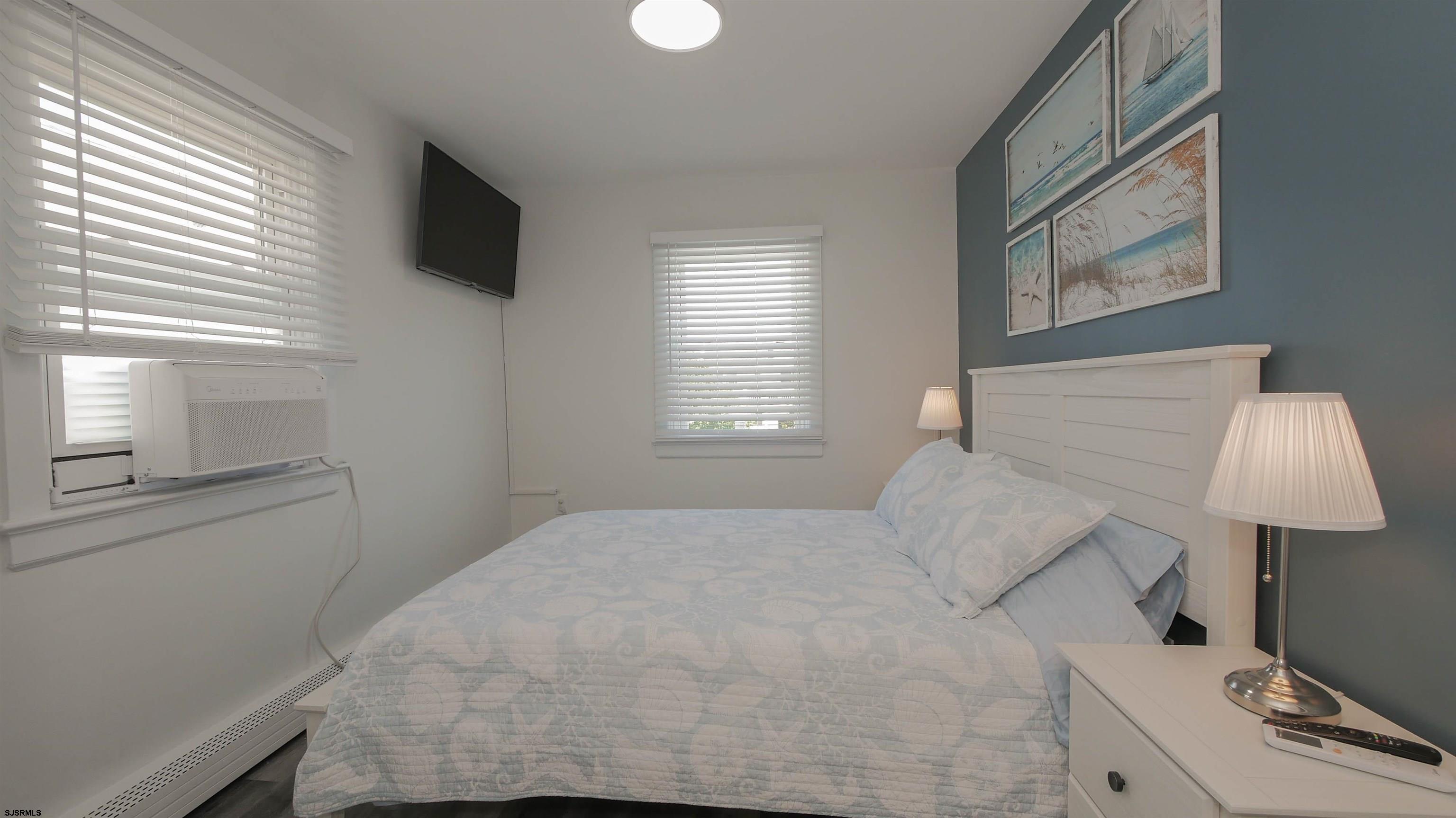 11 South Washington Avenue, Unit 2 Margate City, NJ 08402 - Photo 28 of 35 a bedroom with a bed tv and a window