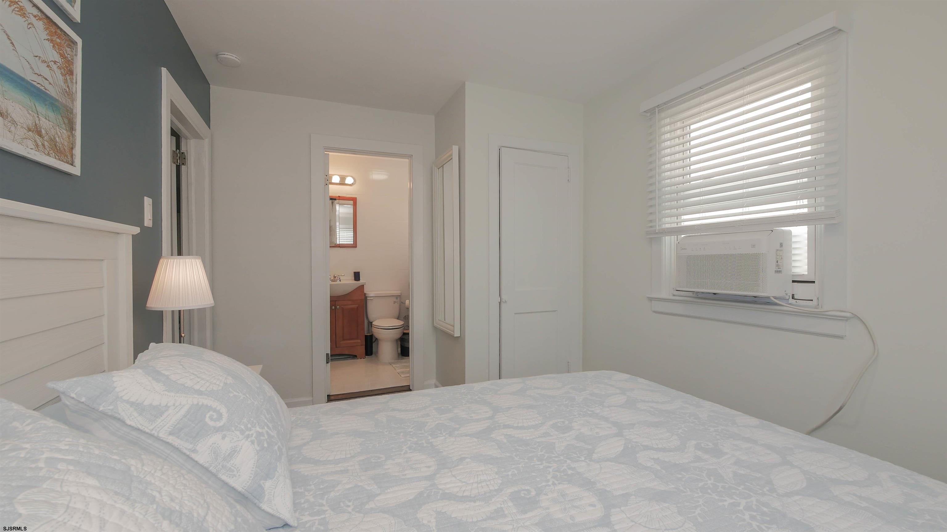 11 South Washington Avenue, Unit 2 Margate City, NJ 08402 - Photo 29 of 35 a bedroom with a bed and a lamp