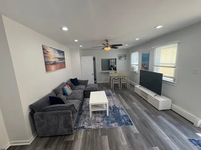 a living room with furniture and wooden floor