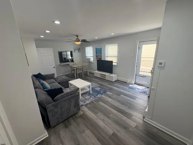 a living room with furniture and a wooden floor