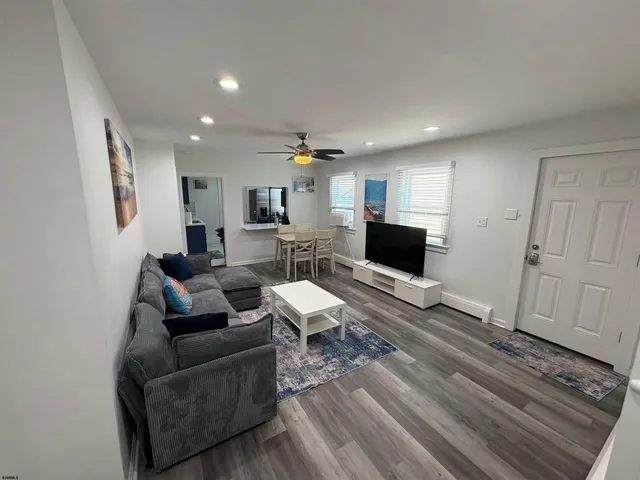 a living room with furniture and a wooden floor