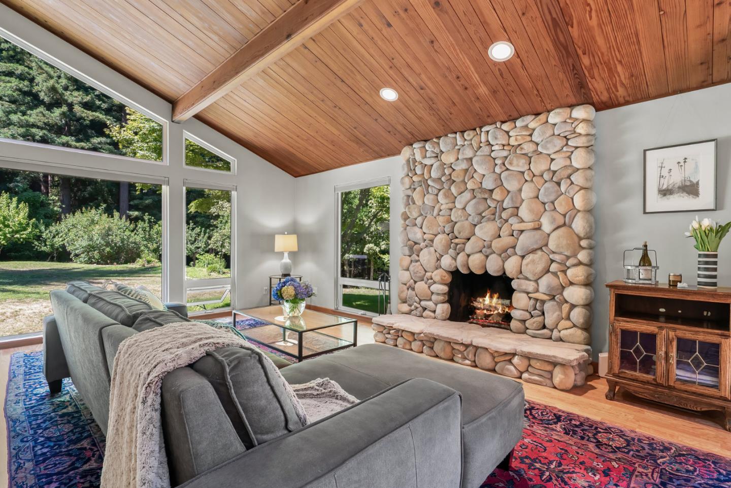 a living room with furniture a fireplace and a floor to ceiling window