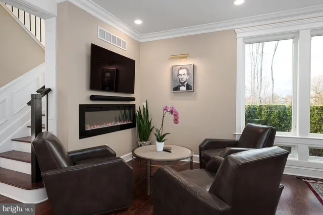 a living room with furniture a flat screen tv and a large window