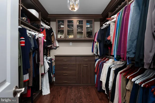 a view of walk in closet with clothes and shoes
