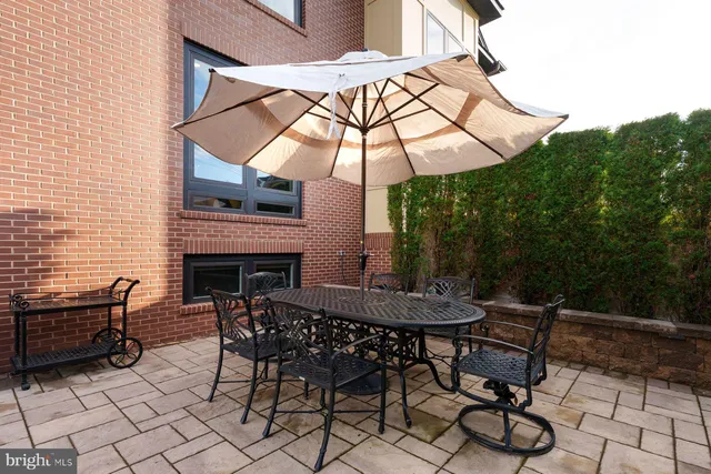 a view of a patio with a table and chairs under an umbrella