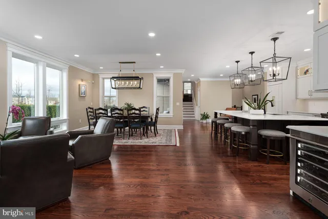 a living room with furniture a wooden floor and kitchen view