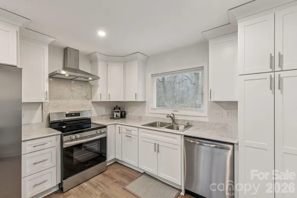 a kitchen with cabinets appliances a sink and a window