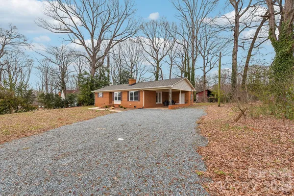 a front view of a house with a yard and trees