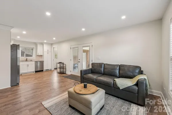 a living room with furniture and a view of kitchen