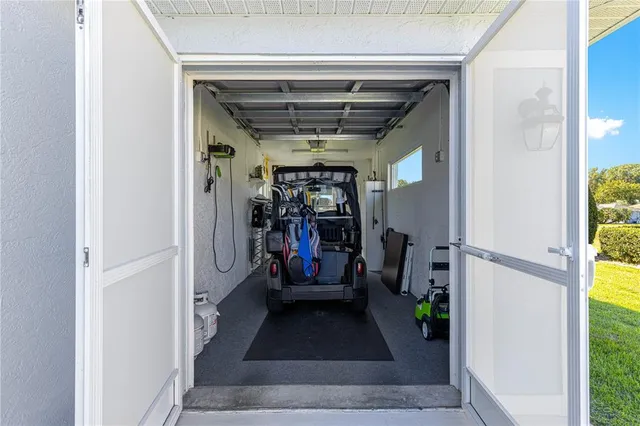 a view of a white house with a big yard and potted plants