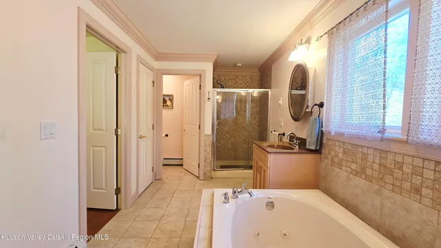 a bathroom with a tub a sink and mirror