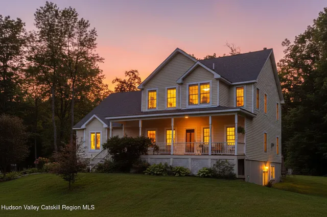 a front view of a house with a yard and trees