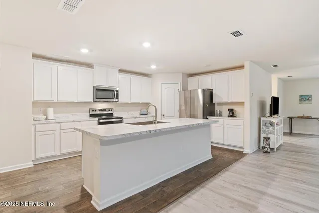 a kitchen with stainless steel appliances granite countertop a sink and a refrigerator
