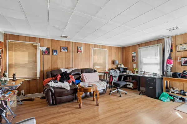 a living room with furniture a flat screen tv and a floor to ceiling window
