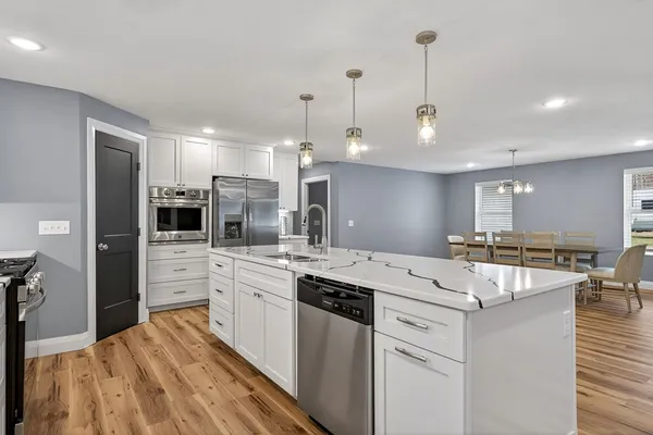 a kitchen with granite countertop a sink cabinets and stainless steel appliances