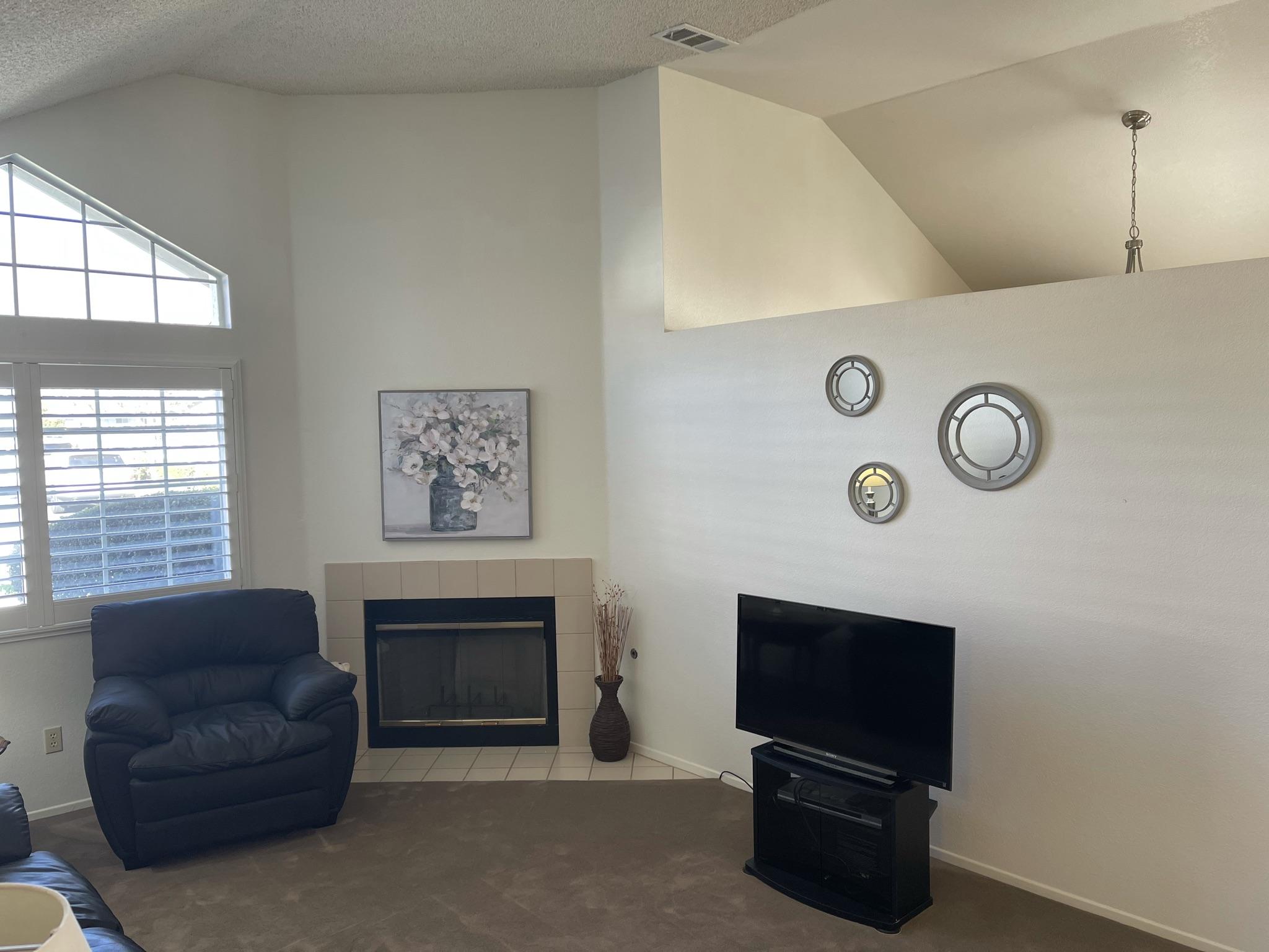 9661 Northampton Drive Rancho Cucamonga, CA 91737 - Photo 3 of 27 a living room with furniture a flat screen tv and a fireplace