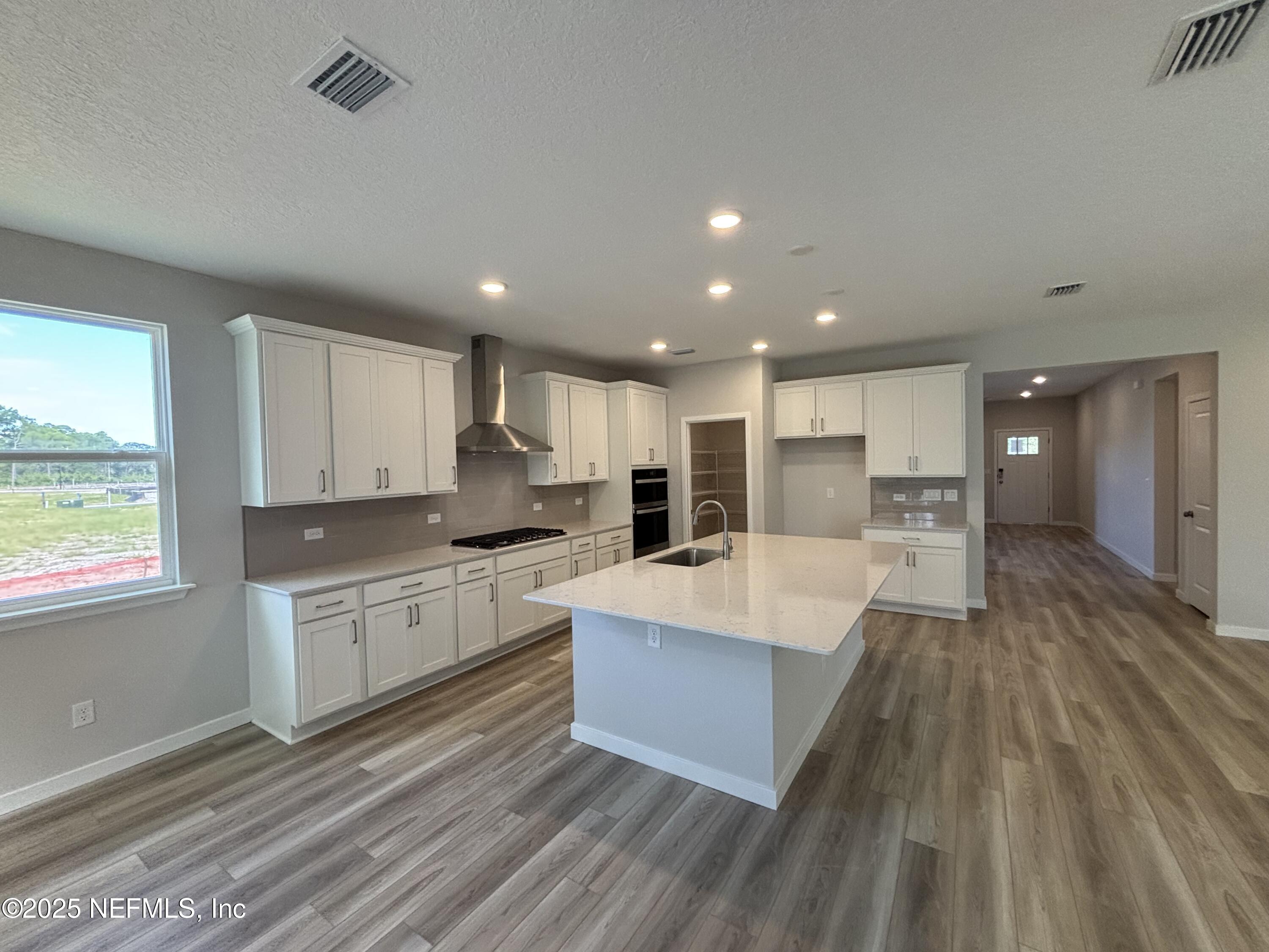 71 Pegasus Road Flagler Beach, FL 32136 - Photo 14 of 25 a large kitchen with stainless steel appliances lots of counter space and wooden floor