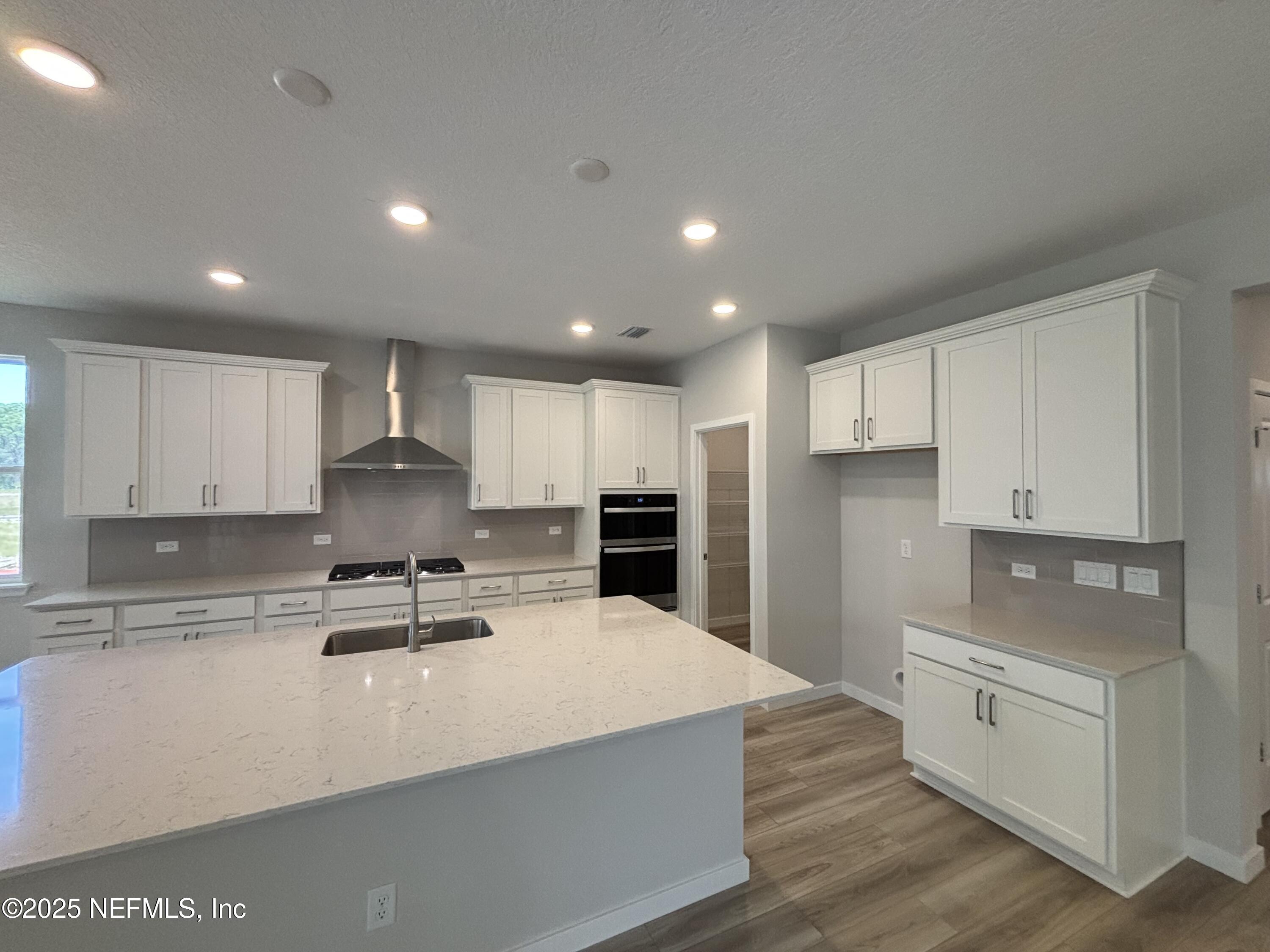 71 Pegasus Road Flagler Beach, FL 32136 - Photo 17 of 25 a kitchen with stainless steel appliances a sink a stove a refrigerator and white cabinets