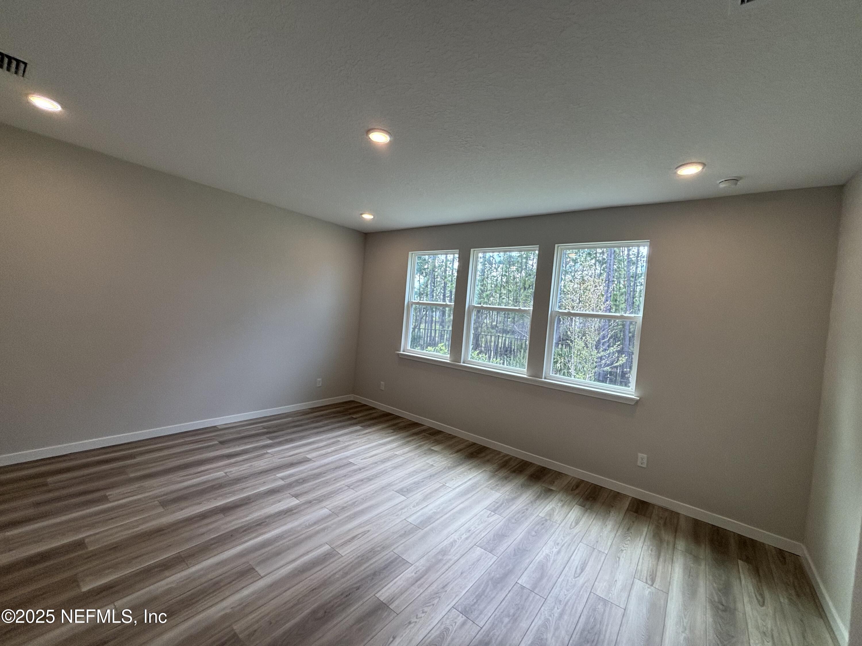 71 Pegasus Road Flagler Beach, FL 32136 - Photo 21 of 25 an empty room with wooden floor and windows
