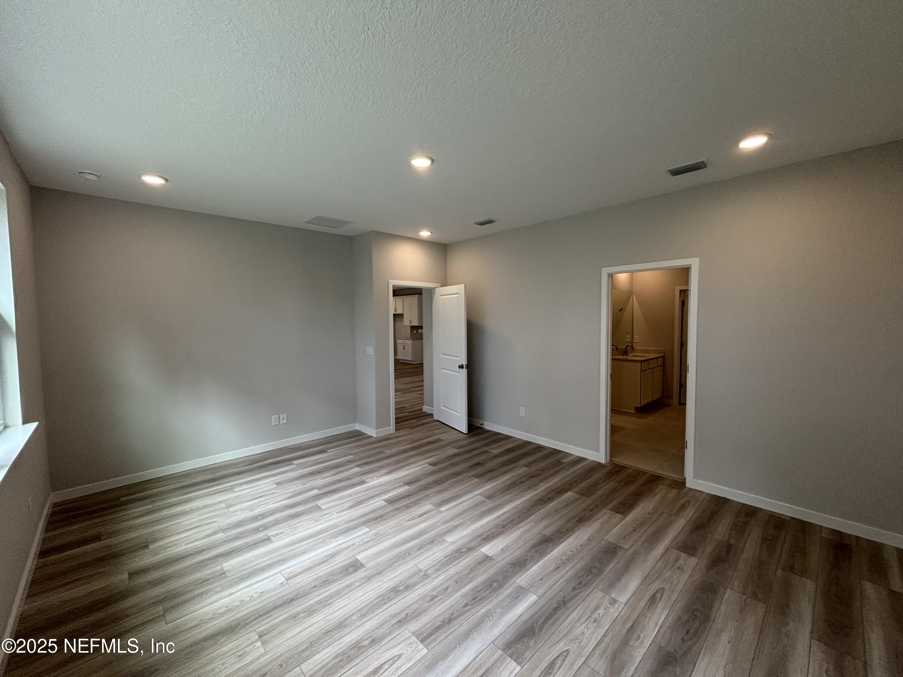 71 Pegasus Road Flagler Beach, FL 32136 - Photo 22 of 25 an empty room with wooden floor and windows