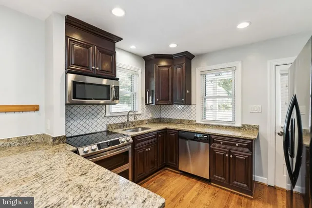 a kitchen with a sink stove top oven and refrigerator