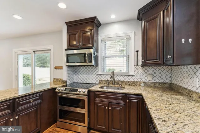 a kitchen with a sink stove and microwave