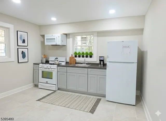 a kitchen with white cabinets and white appliances