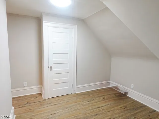a view of an empty walk in closet with wooden floor