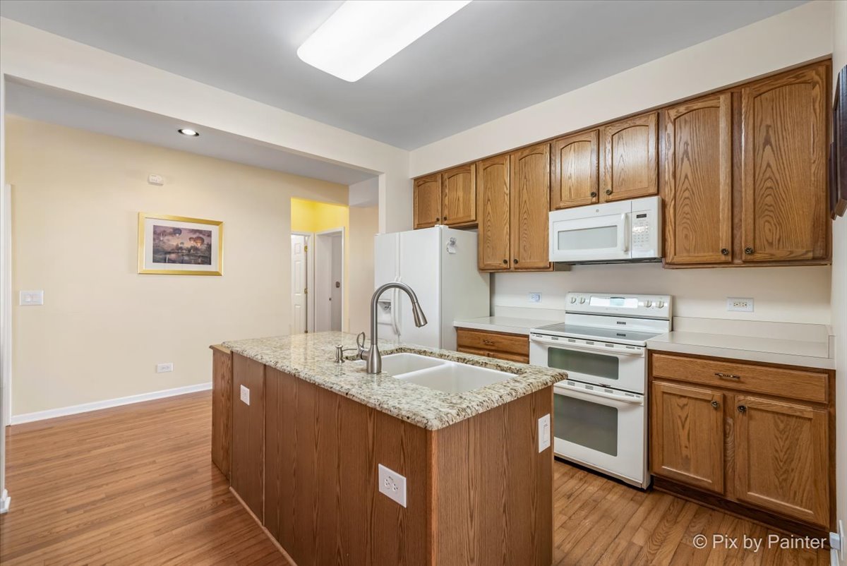 1 Suffolk Way Grayslake, IL 60030 - Photo 19 of 54 a kitchen with granite countertop a sink cabinets and wooden floor