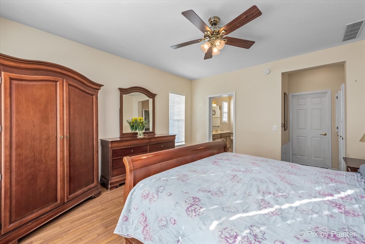 1 Suffolk Way Grayslake, IL 60030 - Photo 28 of 54 a bedroom with a bed and a large mirror with wooden floor