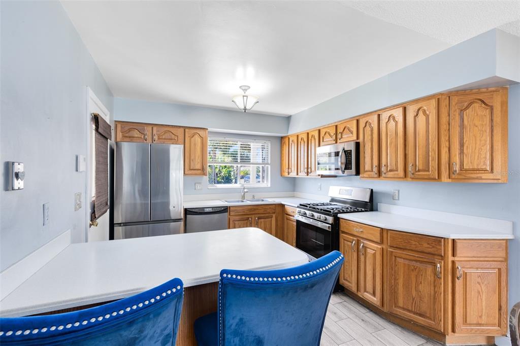 5331 Maize Street Orlando, FL 32821 - Photo 13 of 35 a kitchen with stainless steel appliances granite countertop a sink dishwasher stove and refrigerator with wooden floor