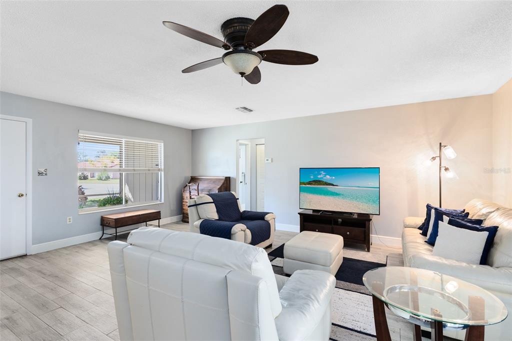 5331 Maize Street Orlando, FL 32821 - Photo 8 of 35 a living room with furniture a flat screen tv and a large window