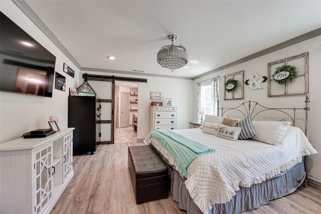 521 Bakers Branch Road Waxahachie, TX 75167 - Photo 20 of 37 Spacious bedroom featuring wood-finish flooring, a crystal chandelier, recessed lighting, and a barn door entry