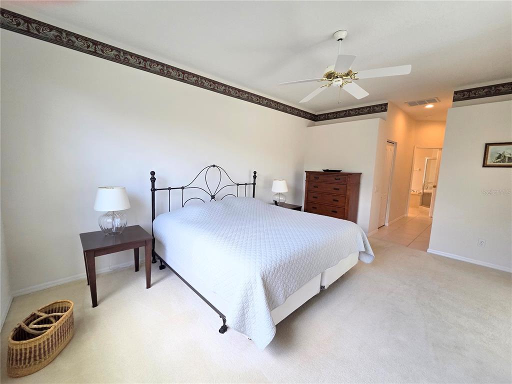 9222 Bonnington Drive Trinity, FL 34655 - Photo 14 of 37 a bedroom with a bed and a chandelier