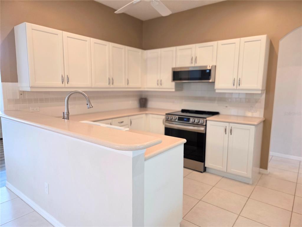 9222 Bonnington Drive Trinity, FL 34655 - Photo 10 of 37 a kitchen with stainless steel appliances granite countertop a sink and a stove