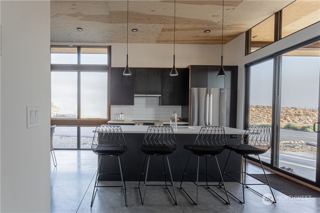 240 Northwest Rattlesnake Point Road Quincy, WA 98848 - Photo 6 of 37 a kitchen with stainless steel appliances a table chairs and a refrigerator